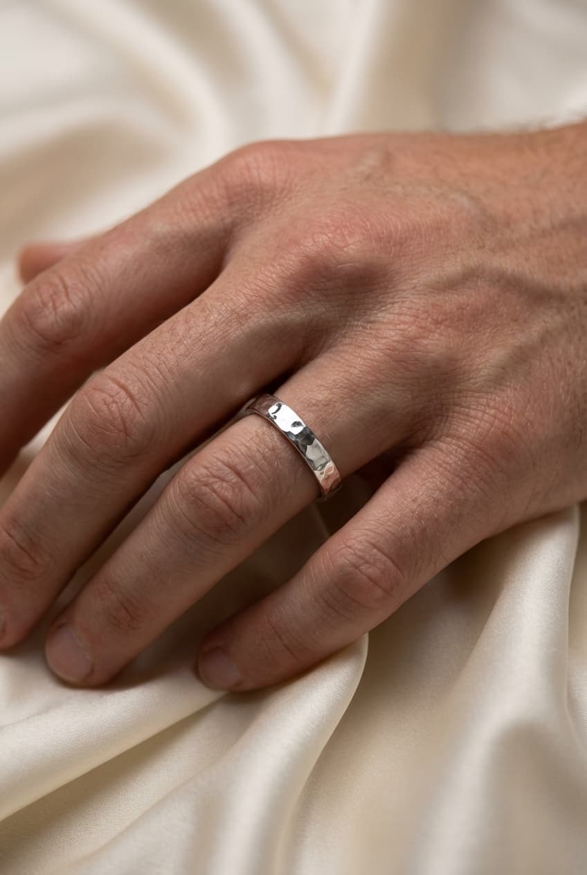 The same ring worn on a hand against a satin fabric background